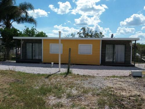 un edificio amarillo con dos ventanas delante en Apartamentos Titilandia, en Piriápolis