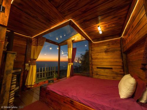 a bedroom with a large window with a bed in it at Skyridge Infinity in Nuwara Eliya