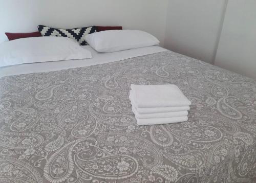 a bed with two pillows and towels on it at Appartamento Gardenia in Saronno