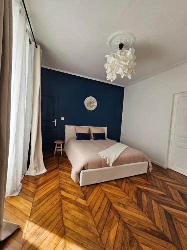 a bedroom with a bed on a wooden floor at L'Écrin Manceau Élégance, Sérénité & Confort in Le Mans