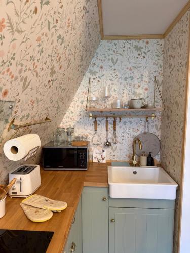 a kitchen with a sink and a microwave at Patak Kuckó cabin ház in Szőce