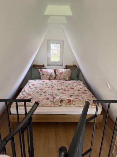 a bedroom with a bed in a attic at Patak Kuckó cabin ház in Szőce