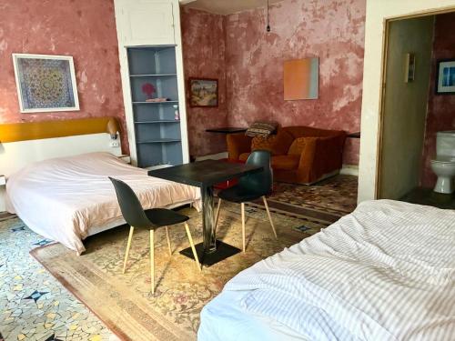 a bedroom with a bed and a table and chairs at Chambres Zohra Centre ville in Decize