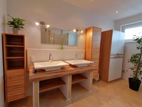 a bathroom with two sinks and a mirror at Gästehaus Marion Appartements in Sankt Peter ob Judenburg
