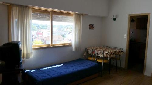 Un dormitorio con una cama azul y una ventana en Frente al Mar en Mar del Plata