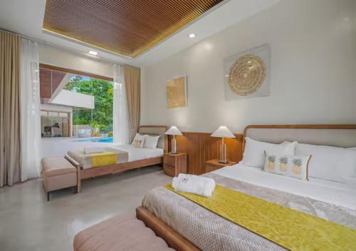 a large bedroom with two beds and a window at Villa Seresa Premium- La Union in Bacnotan