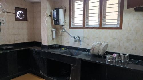 a kitchen with a sink and a phone on the wall at Cheerful homes Mysore stay in Mysore