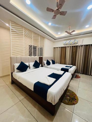 a bedroom with two beds and a ceiling fan at Maa Prabha Courtyard in Varanasi