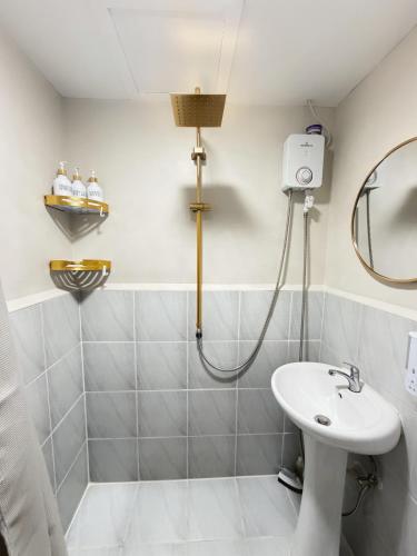 a bathroom with a sink and a shower at The Purrfect Stay in Lapu Lapu City