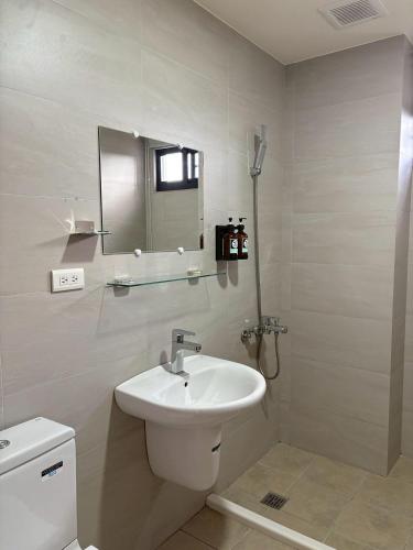 a white bathroom with a sink and a mirror at 日沐澄旅 l 家人聚會 l 烤肉 l 戲水池 l 電動麻將 l KTV l 影音TV in Ch'ih-k'an