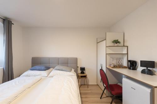 a bedroom with a large bed and a desk at ALS Zimmer & Suiten in Lambach