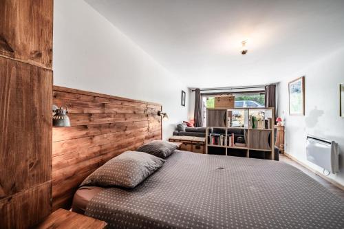 a bedroom with a bed with a wooden headboard at Chalet Tante Emma proche Lac Leman in Vacheresse