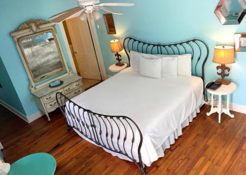 a bedroom with a large bed and a mirror at Creole Gardens Guesthouse and Inn in New Orleans