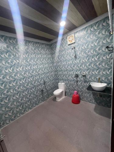a bathroom with a toilet and a sink at Jungle Beach Resort in Neil Island