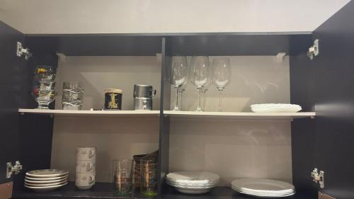 a cabinet with wine glasses and plates on shelves at Apto aconchegante no centro de Manaus in Manaus