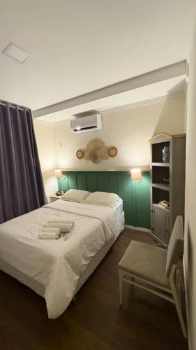a bedroom with a large white bed and a green wall at Apto aconchegante no centro de Manaus in Manaus