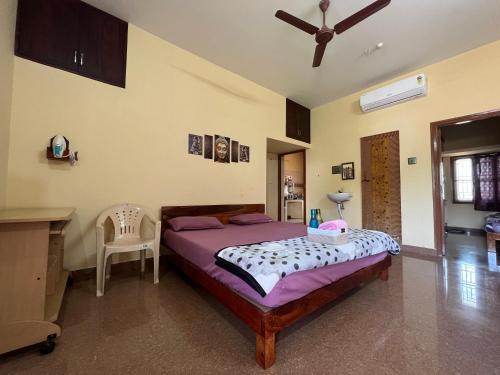 a bedroom with a bed and a table and a chair at Geetham Homestay in Tiruchirappalli