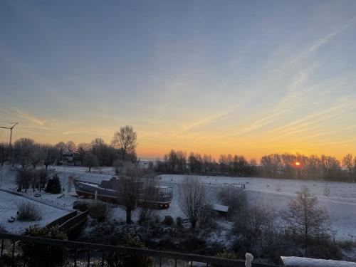 a snow covered field with a sunset in the background at Mein Horumersiel in Horumersiel