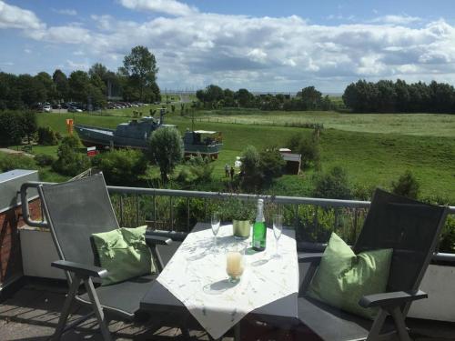 a table and chairs on a balcony with a view of a field at Mein Horumersiel in Horumersiel