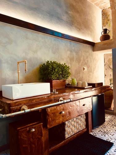 a bathroom with a sink on a wooden counter at Antica e luminosa masseria in Lequile