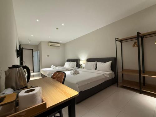a hotel room with two beds and a table at Swing & Pillows - Skudai Johor in Skudai