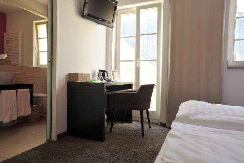 a bedroom with a desk and a bed and a mirror at Cafe Elisabeth in Mutterstadt