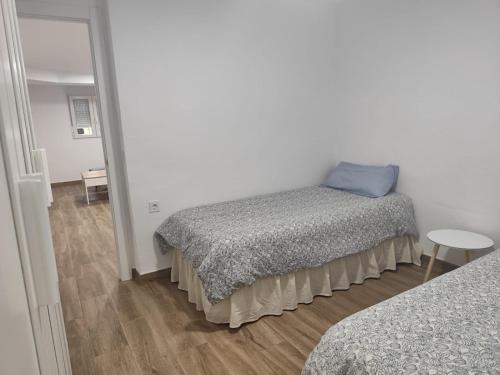 a bedroom with a bed with a blue pillow on it at Las Nubes Mairena in Mairena del Aljarafe