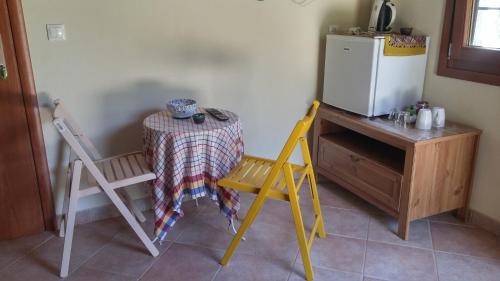 a kitchen with a table and two chairs and a refrigerator at Orly's Villas in Chorefto