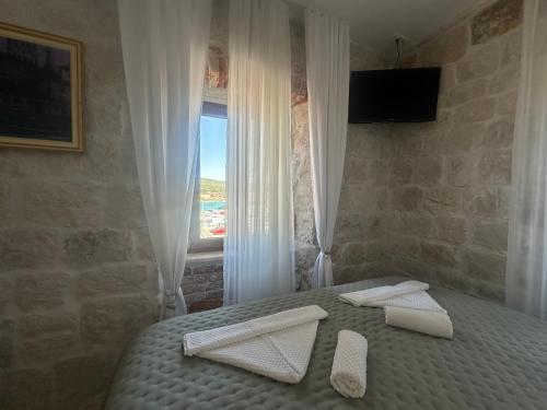 a bedroom with a bed with white towels on it at Boutique Rooms Malo More - Old Town and Parking in Trogir