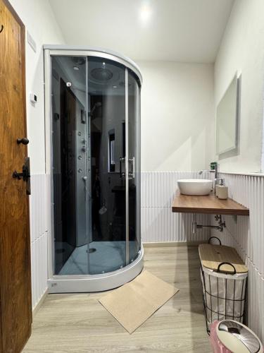 a bathroom with a glass shower with a sink at La Casa sull'Arco in Pacentro