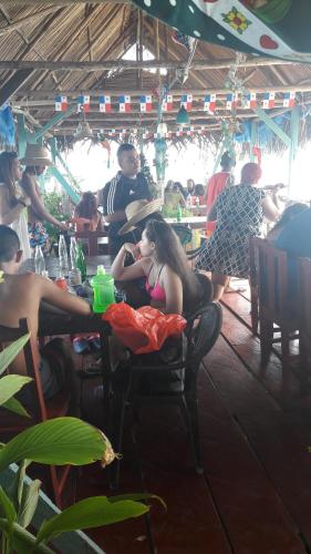 a group of people sitting at tables in a restaurant at Bastimentos Caribean Hotel in Bocas Town