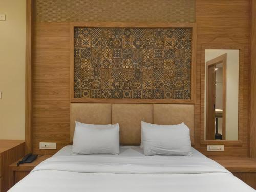 a bedroom with a white bed with a mirror and a bed sidx sidx at Hotel Dolly in Siliguri