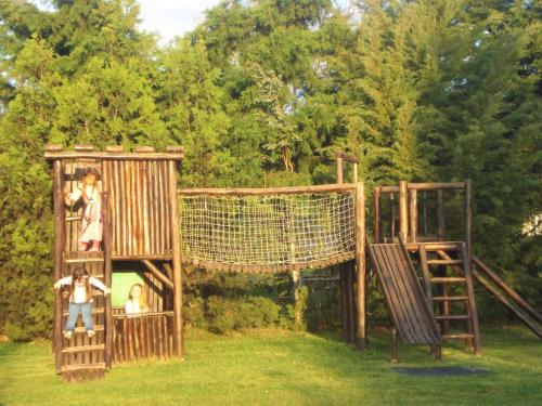 a playground with a net and two kids on it at Cabañas Hoja de la Tierra in Chascomús