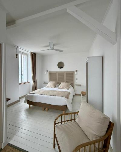 a white bedroom with a bed and a couch at Chambres d'hôtes "Le Petit Cardinal" - proche PuyduFou in Mauléon