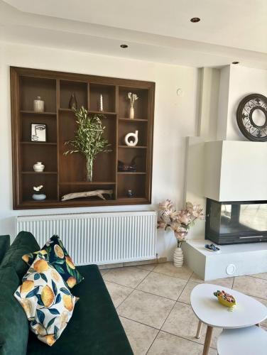 a living room with a green couch and a tv at Lemon Zest in Nea Peramos