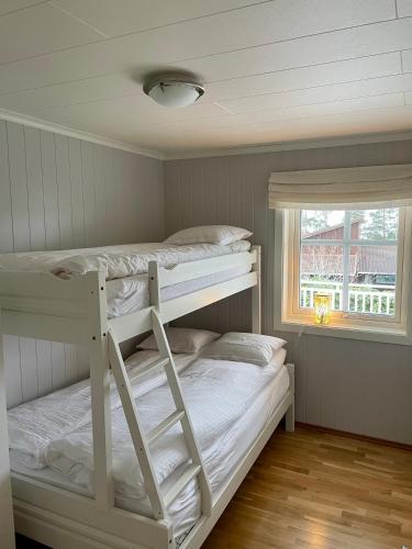 a bedroom with two bunk beds and a window at Villa Nygård in Jelsa