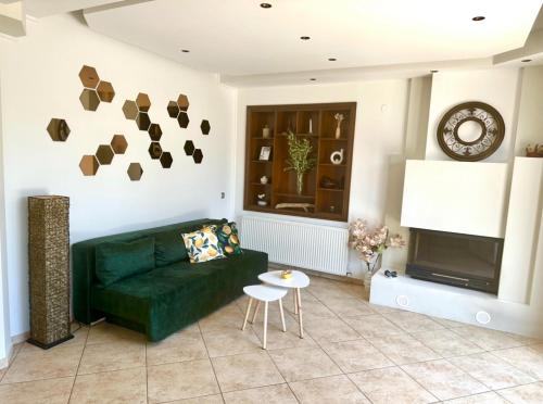 a living room with a green couch and a fireplace at Lemon Zest in Nea Peramos
