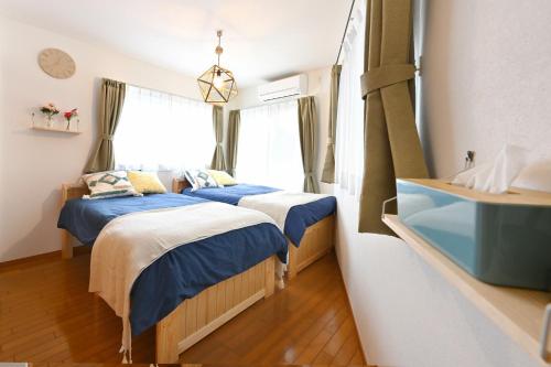 a bedroom with two beds and a window at The triangle hub Miyazaki in Miyazaki