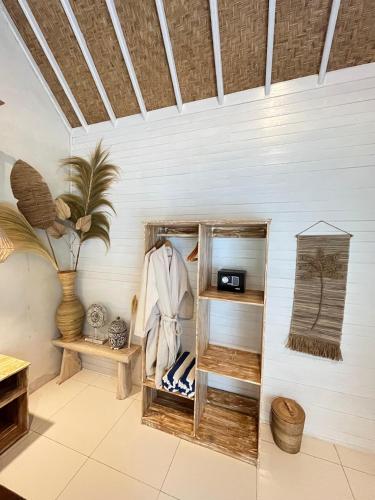 a room with a wooden shelf and a wall at Penida West palm cottage in Nusa Penida