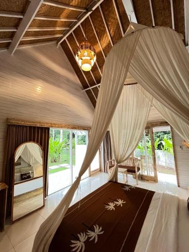 a bedroom with a bed with a mosquito net at Penida West palm cottage in Nusa Penida