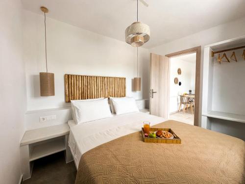 a bedroom with a bed with a tray of fruit on it at Vigla's Tiny House - Steps to the Beach in Mikri Vigla