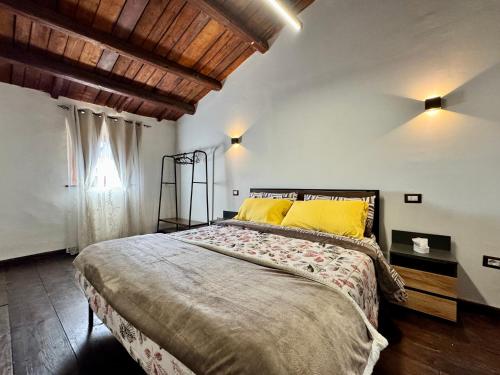 a bedroom with a large bed with yellow pillows at La Casa sull'Arco in Pacentro