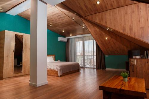 a bedroom with green walls and a bed and a table at Golden Pheasant in Tbilisi City