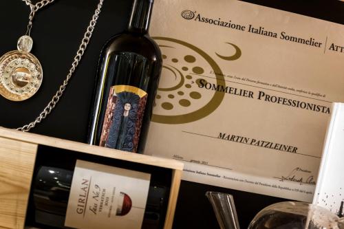 a bottle of wine and a box and a necklace at Helmhotel in San Candido