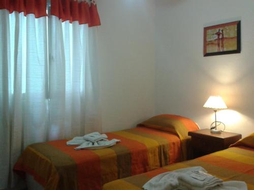 two twin beds in a room with a window at Hotel Wilton in Mar del Plata