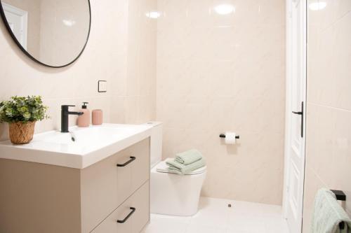 a white bathroom with a sink and a mirror at Mar de Louro in Muros