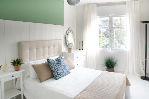a bedroom with a white bed and a window at Mar de Louro in Muros