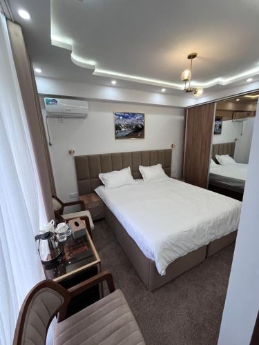 a small bedroom with a bed and a chair at Pamir Silk Road in Qala-i-Khum
