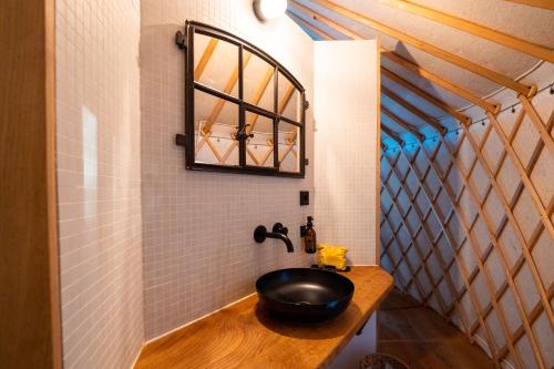 a bathroom with a black sink on a wooden counter at ASTRAEA Jurt Village in Arendsee