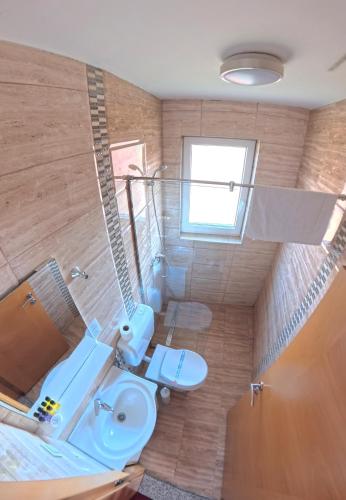 ein Badezimmer mit Waschbecken, Toilette und Fenster in der Unterkunft Nihad B&B in Visoko